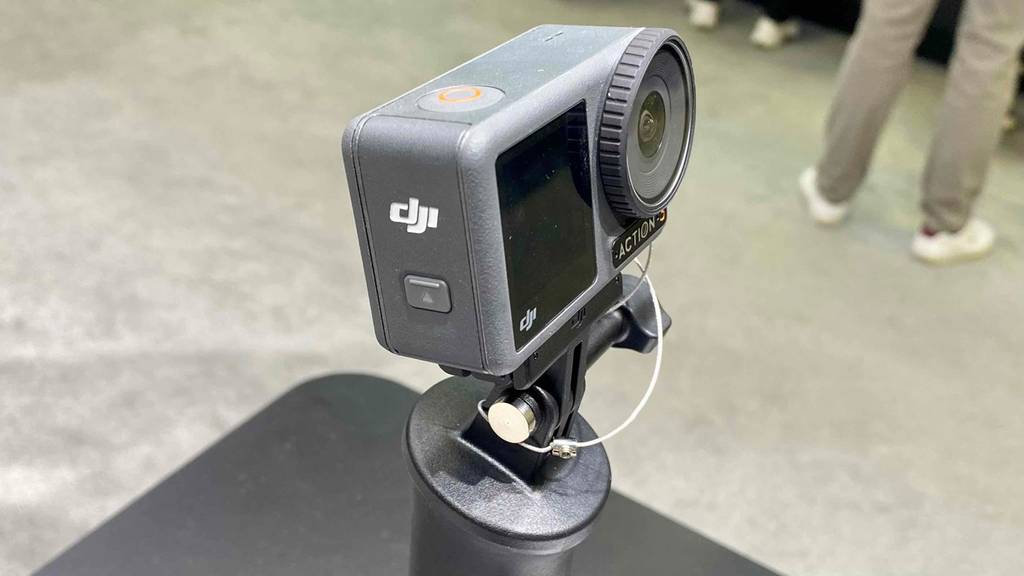 Im Test: Seitenansicht einer Mini-Kamera von Dji, an schwarzer Fläche befestigt.