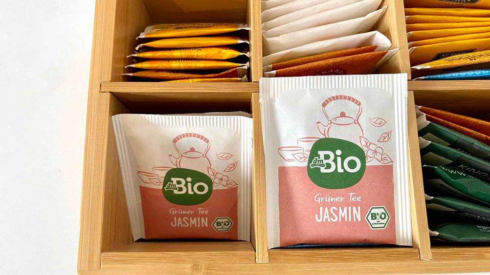 Im Test: Ein Päckchen Jasmintee neben anderen in einer Holzkiste.