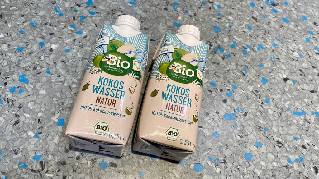Kokoswasser im Test: zwei Tetrapack Bio Kokosmilch von DM auf gesprenkeltem Untergrund.