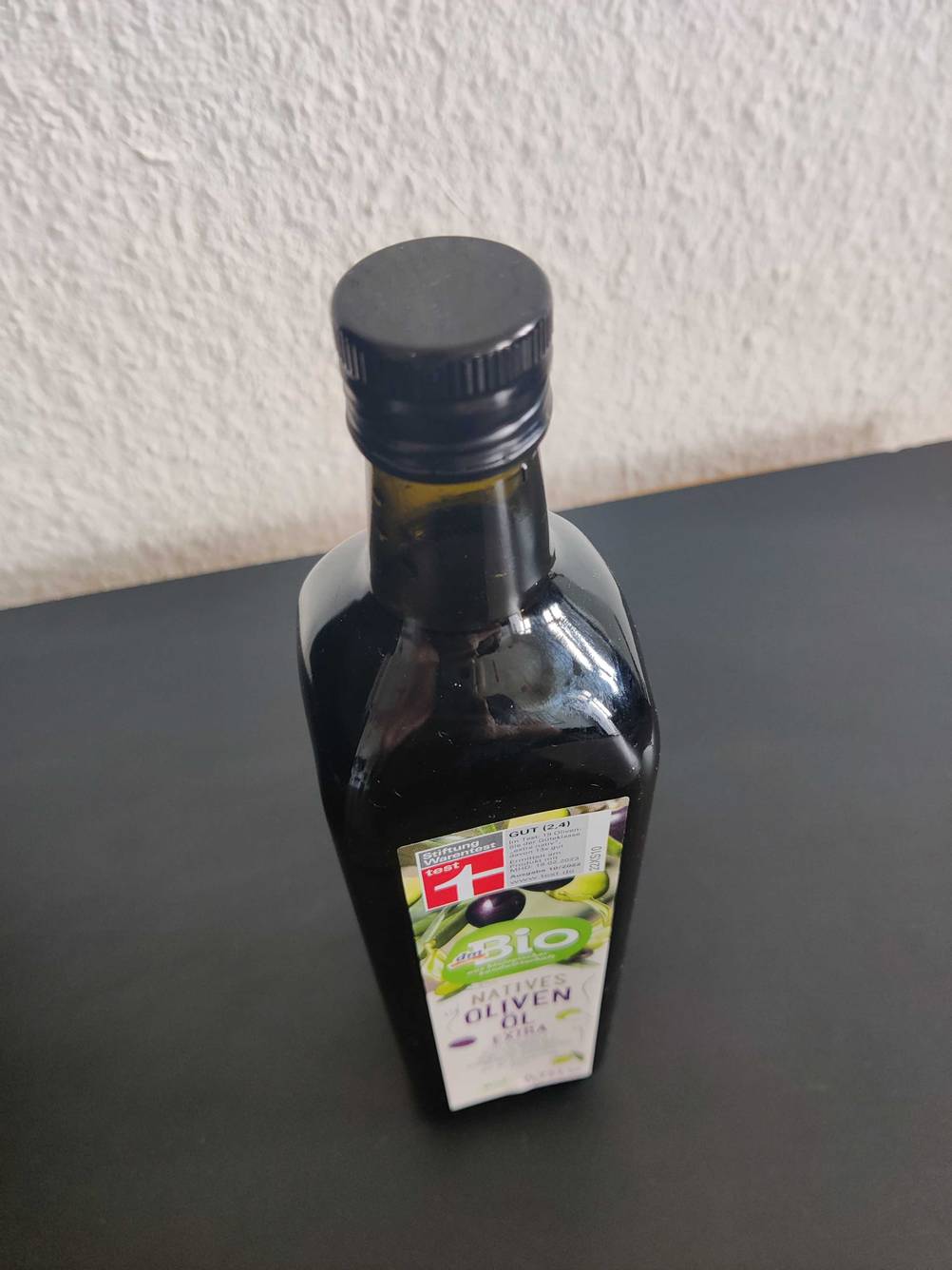 Nahaufnahme des Deckels einer Flasche Bio-Olivenöl auf einer dunklen Fläche.
