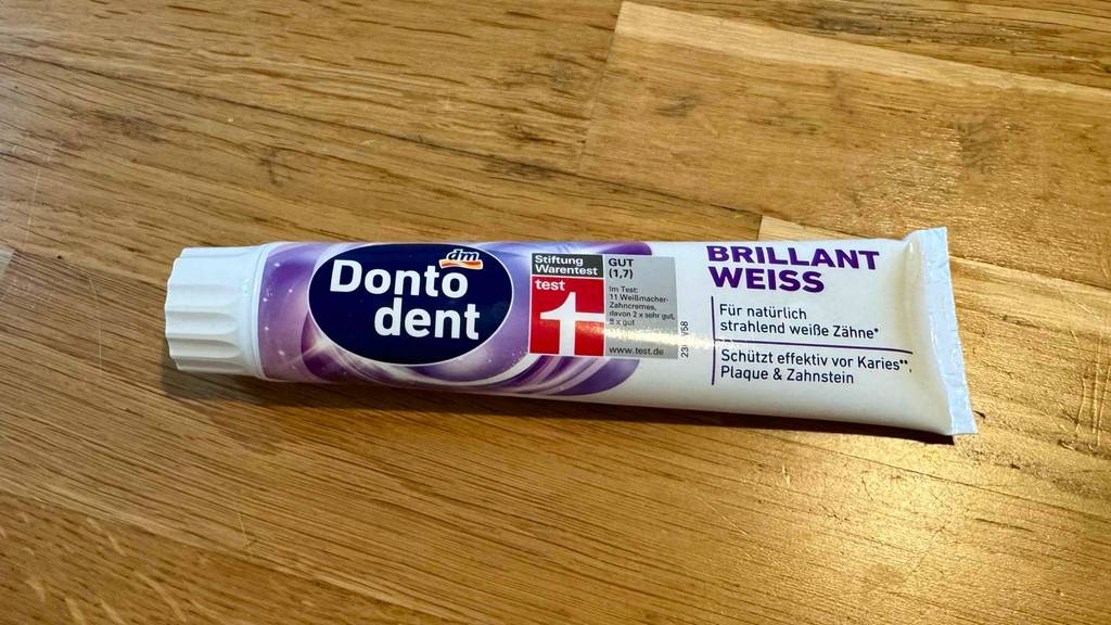 Getestet: Eine Zahnpasta für weiße Zähne liegt auf einer Holzfläche.