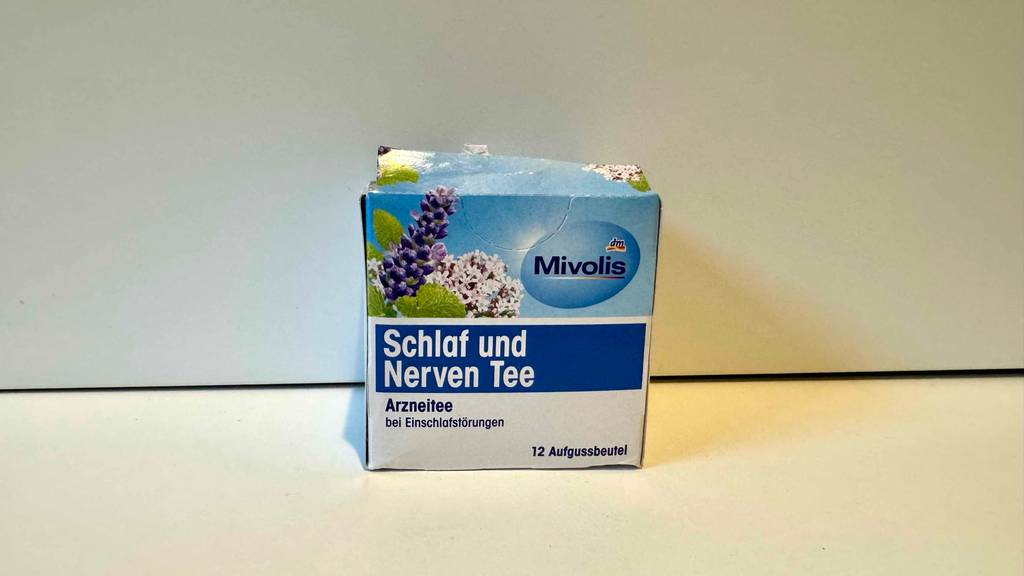 Die Verpackung von getestetem Schlaf-und-Nerventee steht in einem weißen Regal.