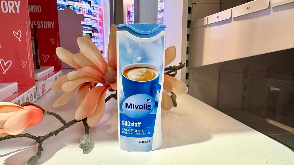 Eine Dose mit getesteten Süßstoff-Tabletten steht zum testen vor einer Blume.