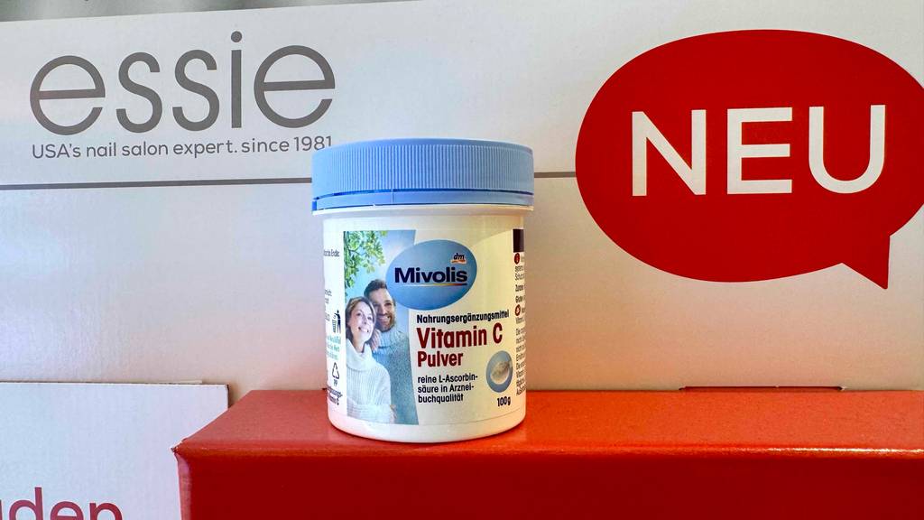 Eine Dose Vitamin-C-Pulver steht zum testen auf einem roten Display.