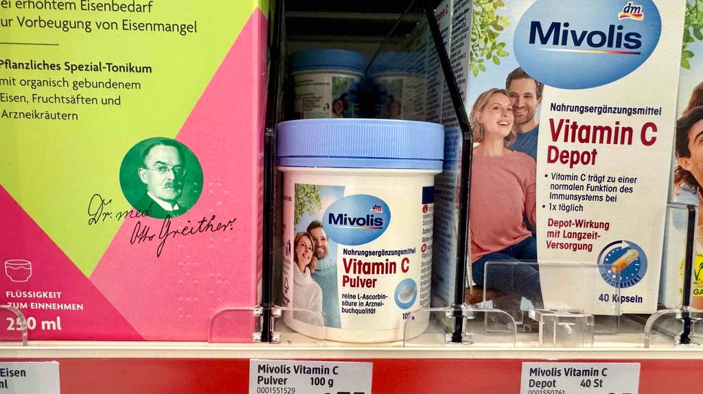 Vitamin-C-Pulver im Test: Eine Dose steht zwischen anderen Produkten in einem Regal.