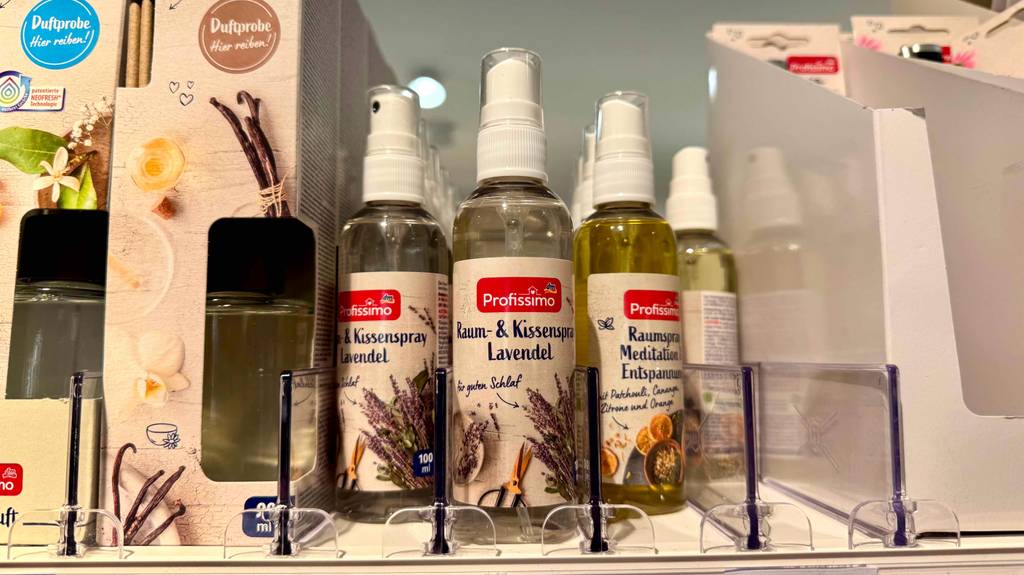 Kissenspray im Test: Mehrere Zerstäuber stehen neben- und hintereinander zwischen anderen Produkten in einem Regal.
