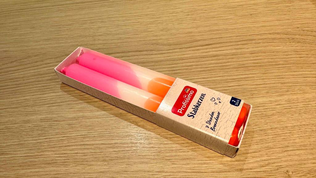 Stabkerzen-Test: Ein in Kartonage verpacktes 2er-Set liegt quer auf einer Holzfläche.