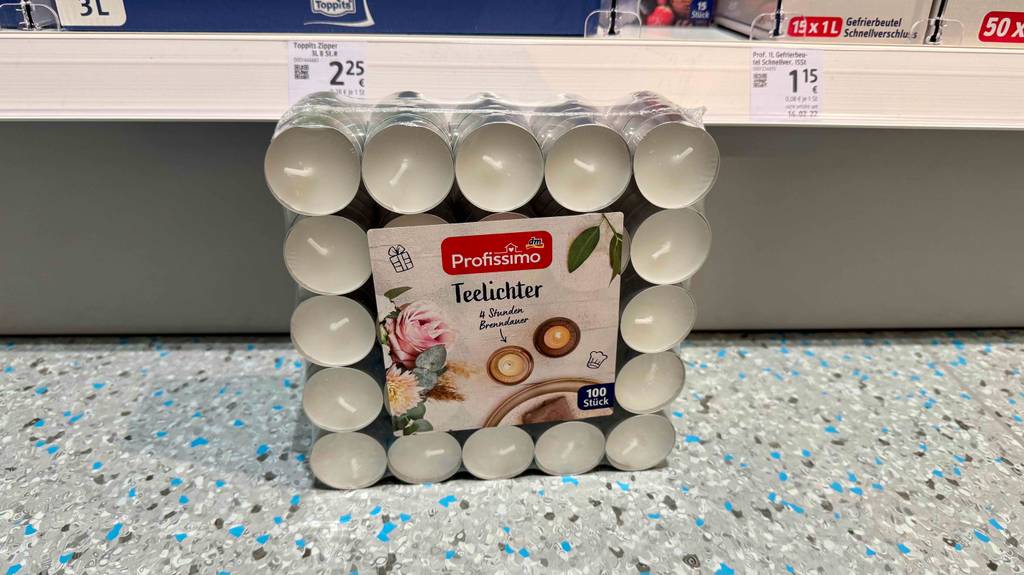 Eine 100er-Packung Teelichter steht zum testen auf einem Boden.