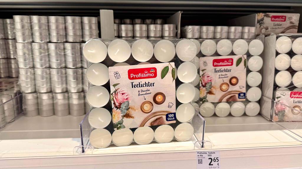 Teelicht im Test: Mehrere Packungen stehen und liegen in einem Regal.