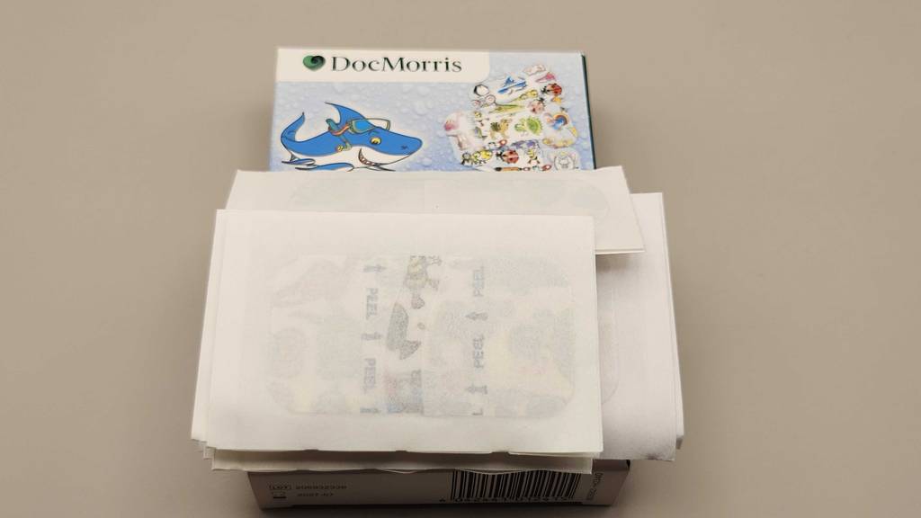Getestete Pflasterstrips für Kinder liegen auf einer Verpackung der Marke Doc Morris.