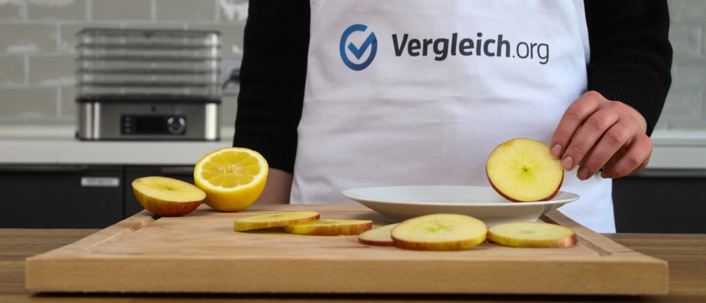 Äpfel werden auf einem Holzbrett für den Dörrautomaten vorbereitet.