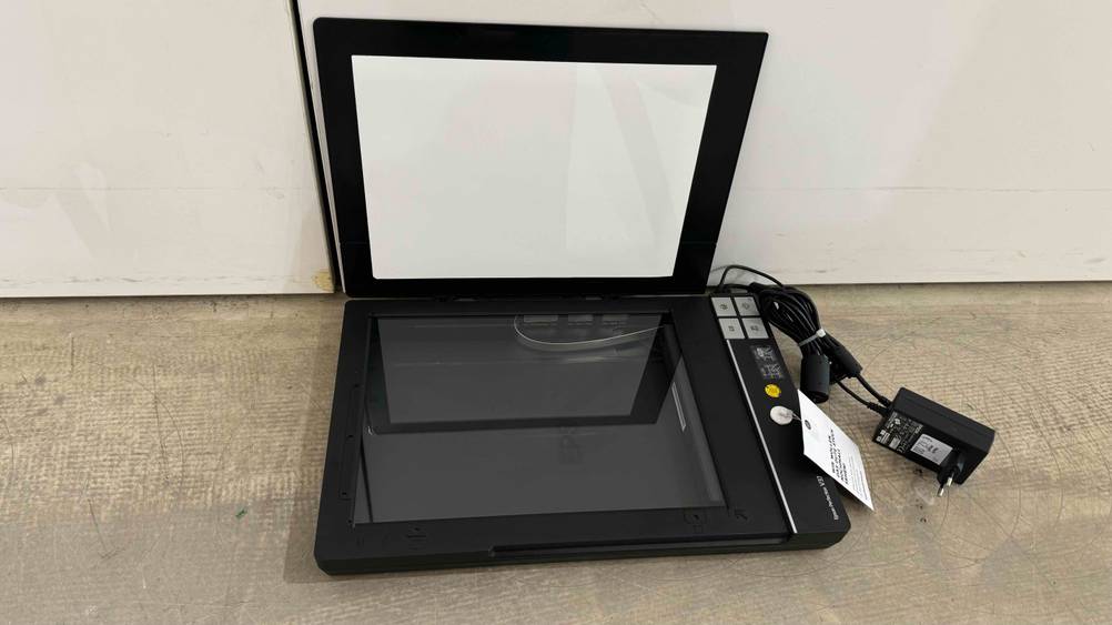 Ein getesteter Dokumentenscanner mit geöffnetem Deckel vor einer hellen Wand.