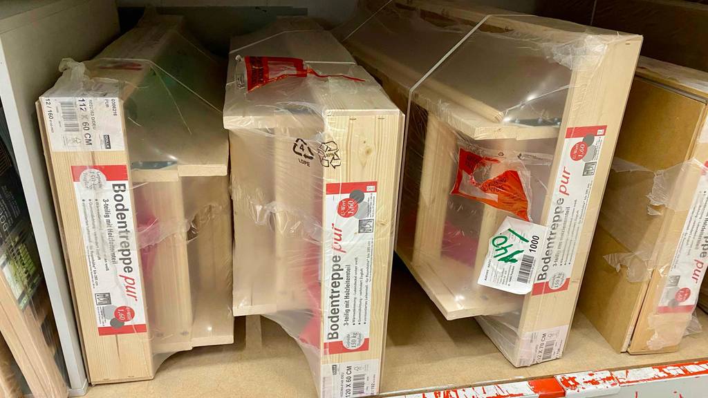 Bodentreppen-Test: Mehrere in Zellophan eingeschweißte Modelle aus Holz stehen nebeneinander in einem Verkaufsregal.