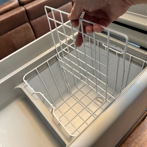 Eine Hand legt ein Trenngitter in die Dometic CoolFreeze CFX 35