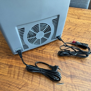 Die Stromkabel der Dometic TropiCool TC 21FL liegen neben dem Gerät auf einem Tisch.