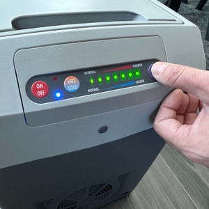 Eine Hand drückt einen Knopf auf der Dometic TropiCool TC 21FL.