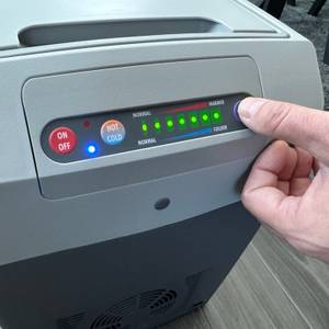 Eine Hand drückt einen Knopf auf der Dometic TropiCool TC 21FL.