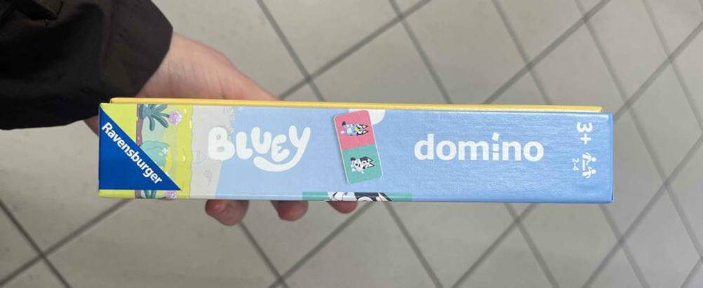 Eine Hand zeigt die schmale Seite inklusive Altersangabe der Verpackung mit dem getesteten Domino-Spiel.