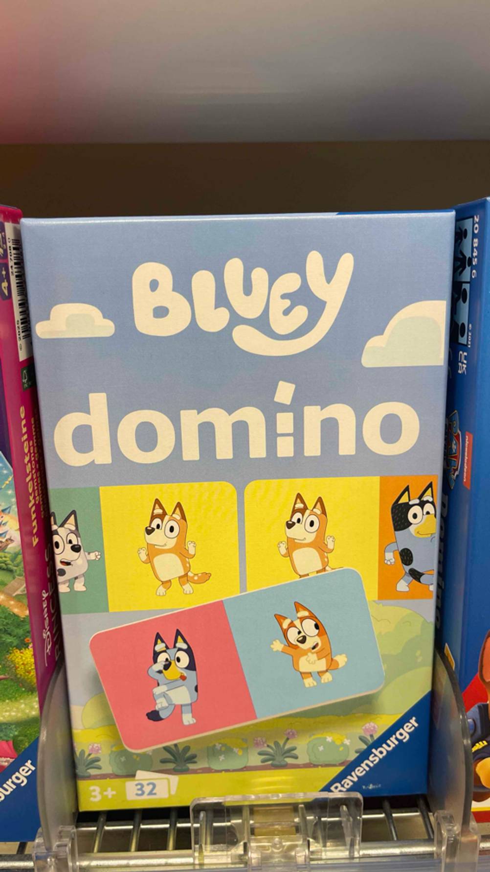 Das getestete Domino-Spiel in der hellblauen 32-Teile-Packung von Ravensburger, ab 3+, steht in einem Verkaufsregal.