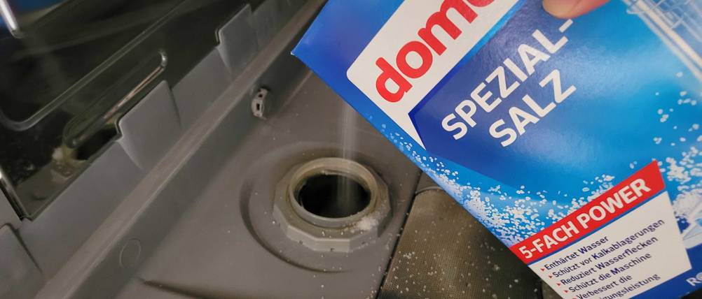 Eine Spülmaschine wird mit domol Spezialsalz aufgefüllt.