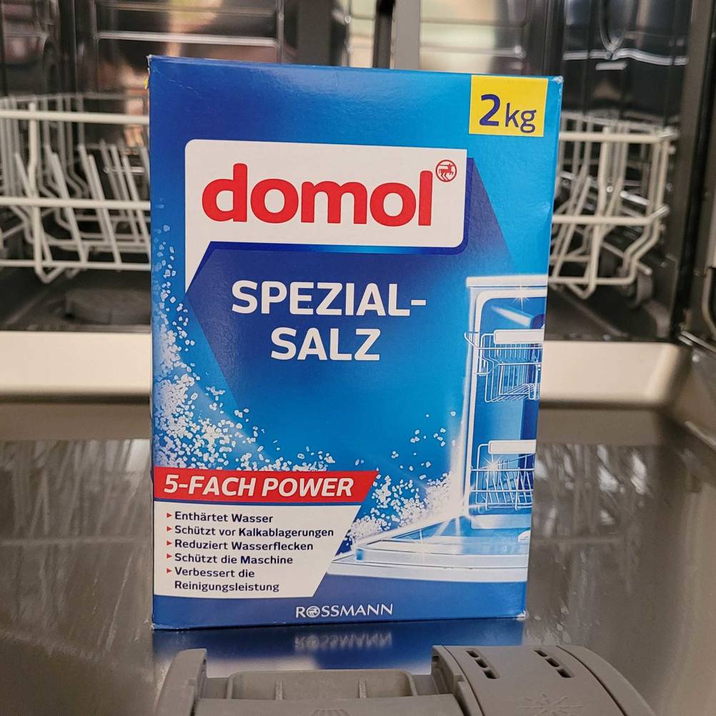 domol Spezialsalz steht auf der geöffneten Spülmaschine.