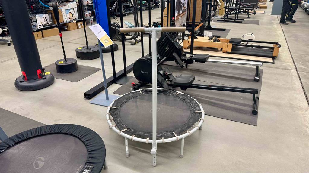 Ein Fitnesstrampolin steht zum Testen mit anderen Geräten in einem großen Raum.
