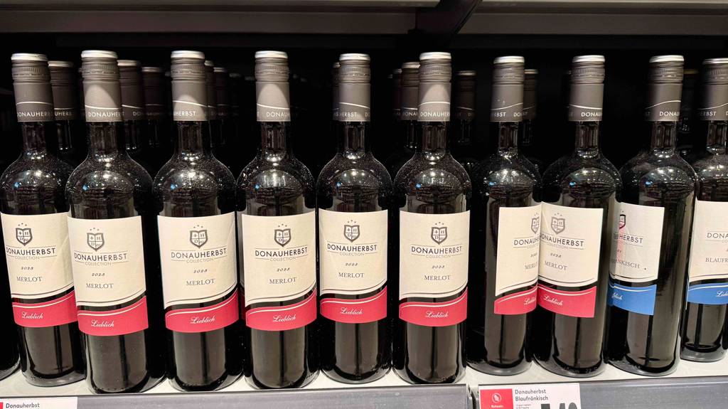 Merlot im Test: Mehrere Flaschen stehen neben- und hintereinander in einem Regal.