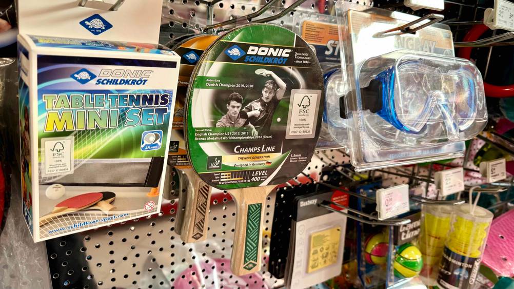 In einem Regal mit anderen Produkten zusammen hängt ein getesteter Donic-Tischtennisschläger.