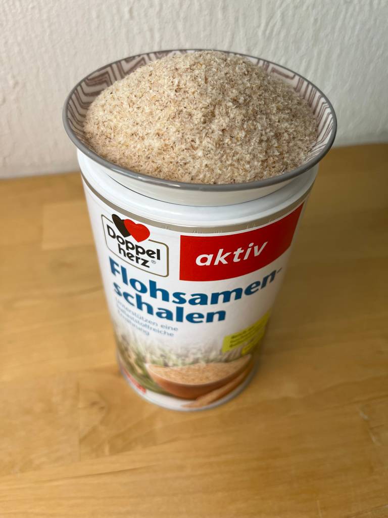 Eine Schale Flohsamen auf der Packung stehend.