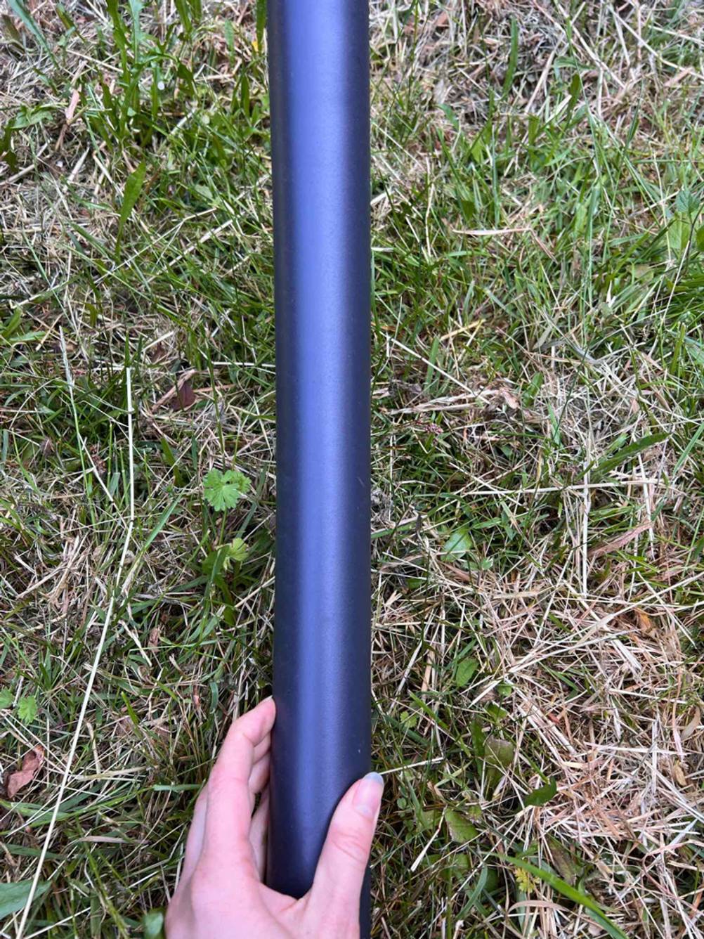 Eine Hand hält eine Stange der getesteten Doppelliege.
