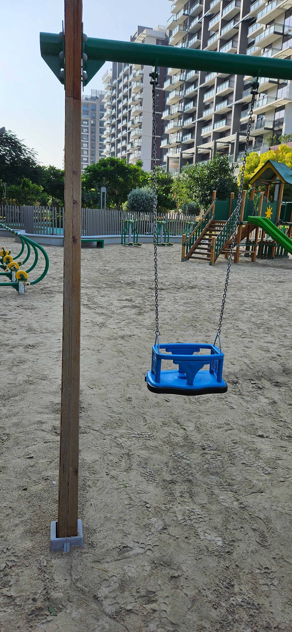 Linke Seite einer Doppelschaukel im Test mit einem Baby-Sitz.