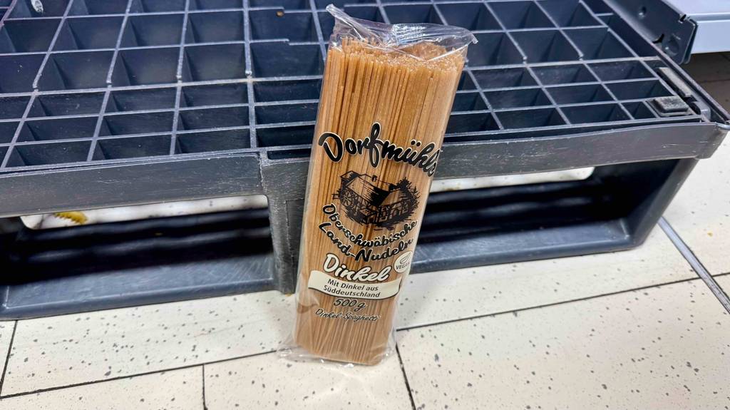 Eine Packung Dinkel-Spaghetti steht zum Testen vor einer kleinen Palette.