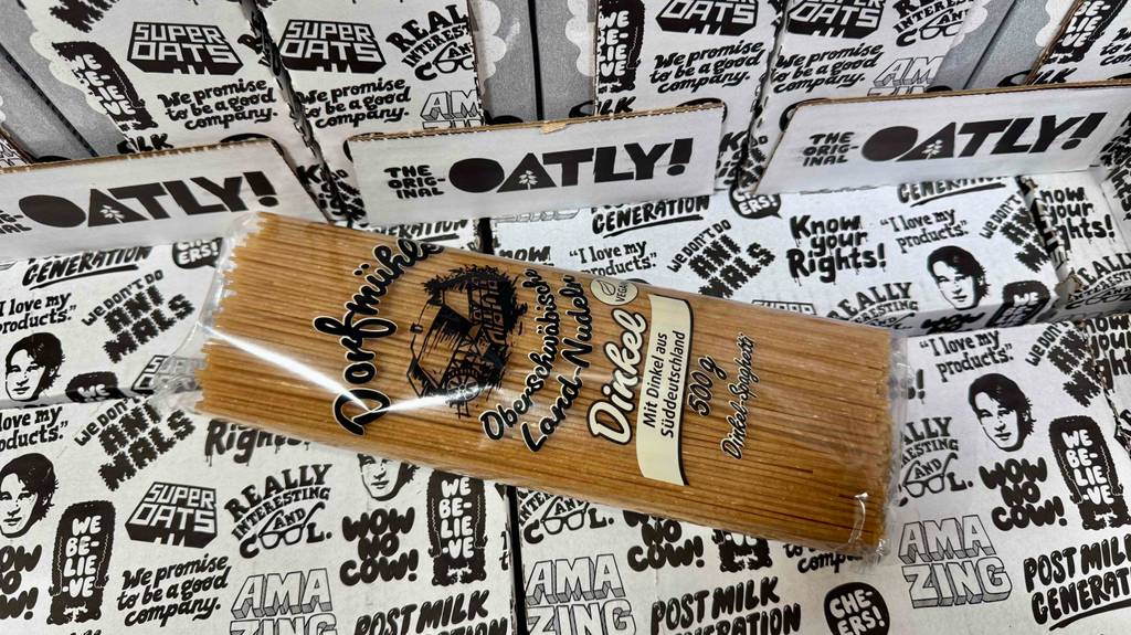 Eine Packung getestete Dinkel-Spaghetti liegt auf mehreren Kartons im Popart-Design.
