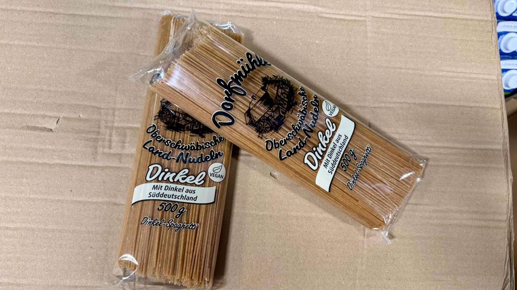 Dinkel-Spaghetti-Test: Zwei Packungen liegen quer aufeinander auf einem Karton.