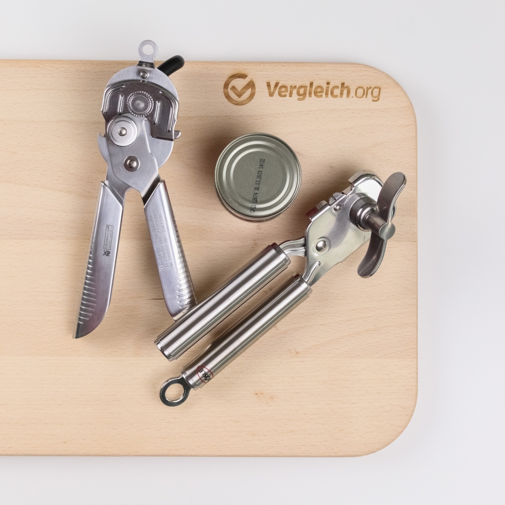 zwei Dosenöffner mit Dose auf einem Holzbrett 