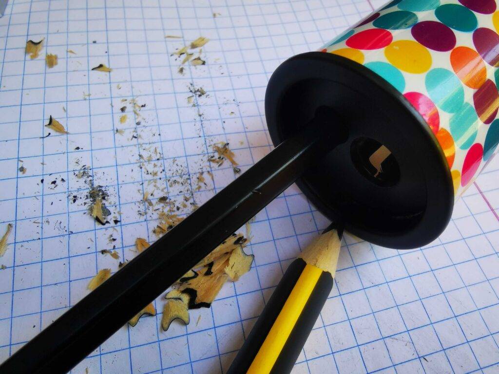 Dosenspitzer getestet: Nahaufnahme des Dosenspitzer-Kopfs mit eingeführtem Stift. Beide liegen auf einem Matheheft.