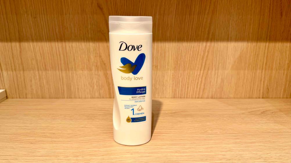 Eine Flasche der getesteten Dove-Bodylotion in einem Holzregal.