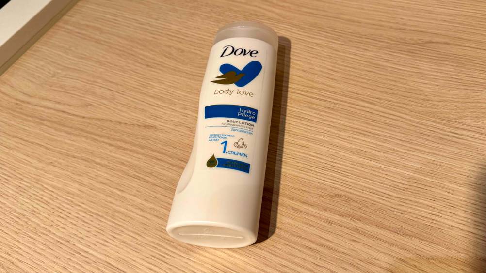 Auf einer Holzfläche liegt eine Flasche Dove-Bodylotion im Test.