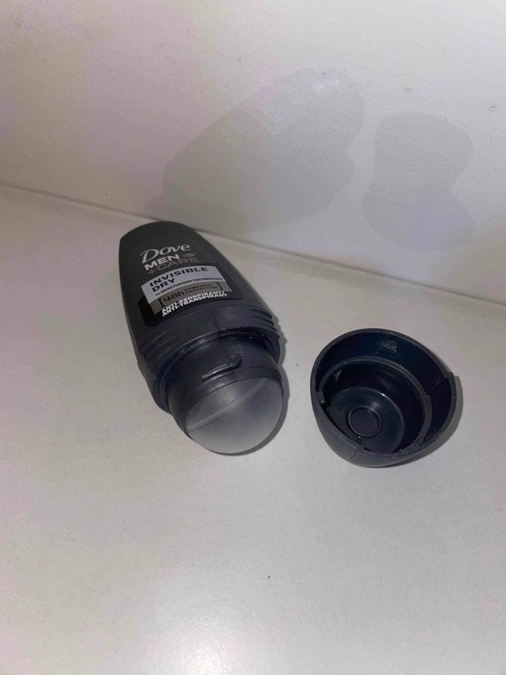 Nahaufnahme der Kugel eines Deo-Roller für Herren auf einer hellen Fläche, die Kappe liegt daneben.