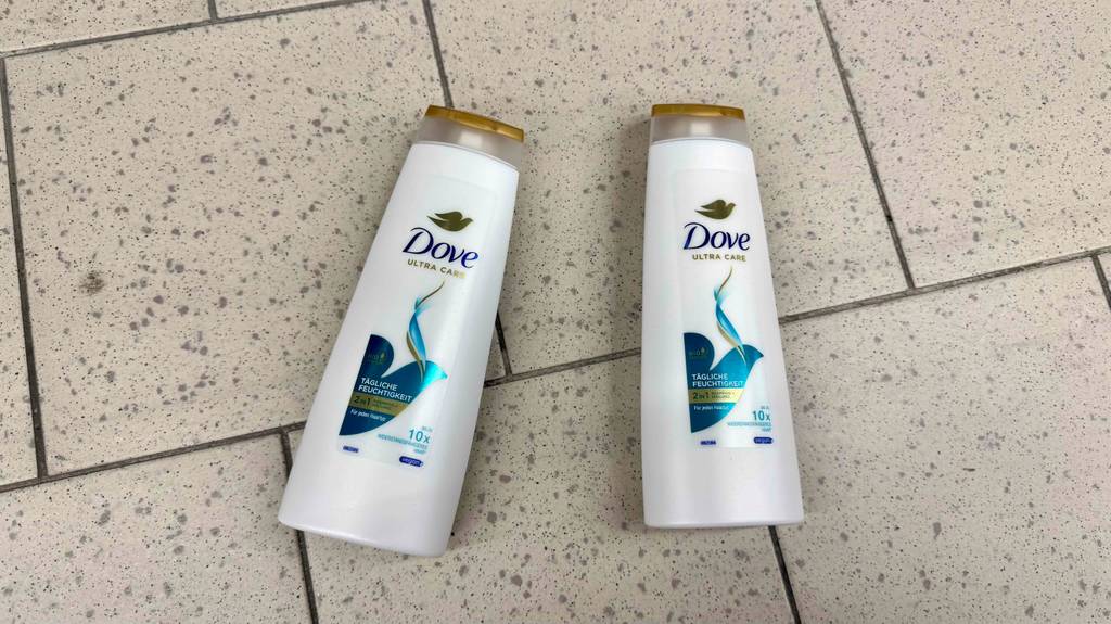 Dove-Shampoo Test: Zwei weiße Quetschflaschen liegen auf einem Fliesenbelag.