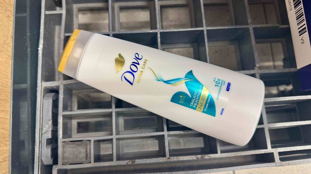 Dove-Shampoo-Test: Eine weiße Quetschflasche liegt auf einem Gitter.