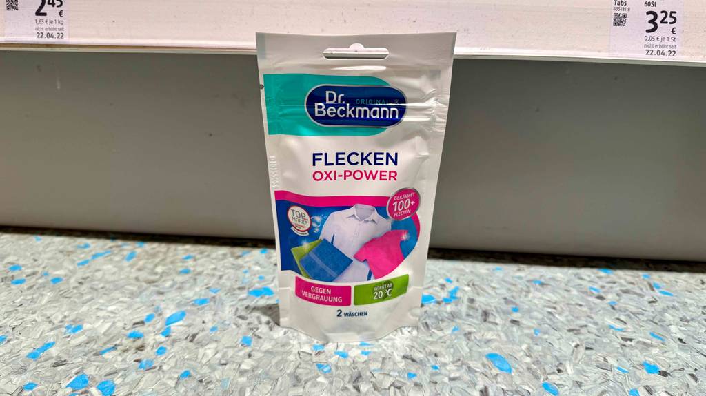 Getestetes Fleckensalz in einem wiederverschließbaren Beutel von Dr. Beckmann steht vor einem Regal auf dem Boden des Drogeriemarktes.