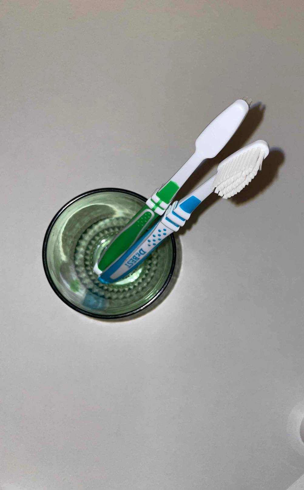 zwei Zahnbürsten von Dr. Best in einem Zahnputzbecher.