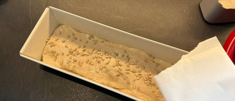 Sonnenblumenkerne werden auf ein Brot in der Dr. Oetker 4855 Brotbackform gegeben