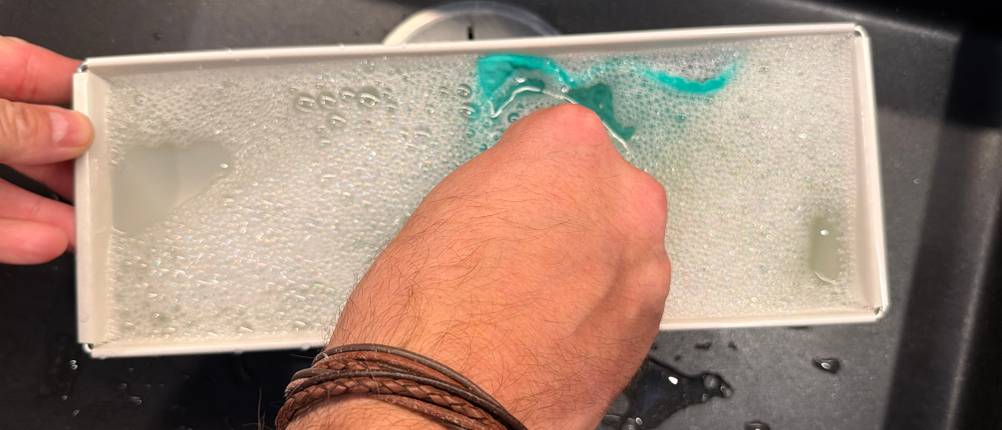 Eine Hand reinigt die Dr. Oetker 4855 Brotbackform