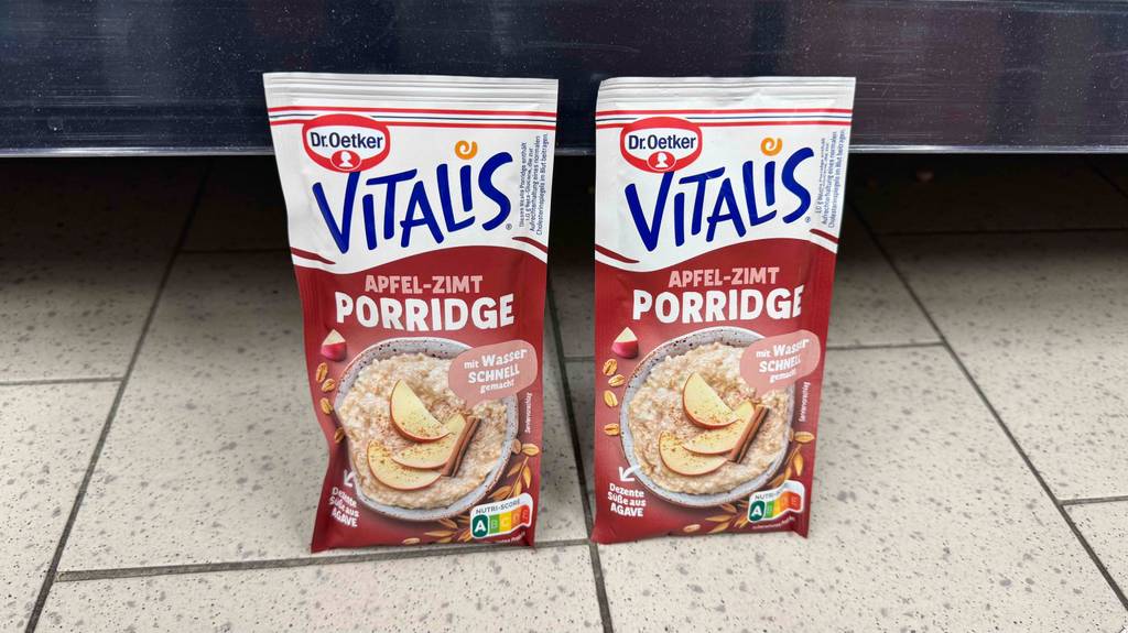 Zwei Packungen mit Fertig-Porridge im Test stehen nebeneinander vor einem Regal auf dem Boden.