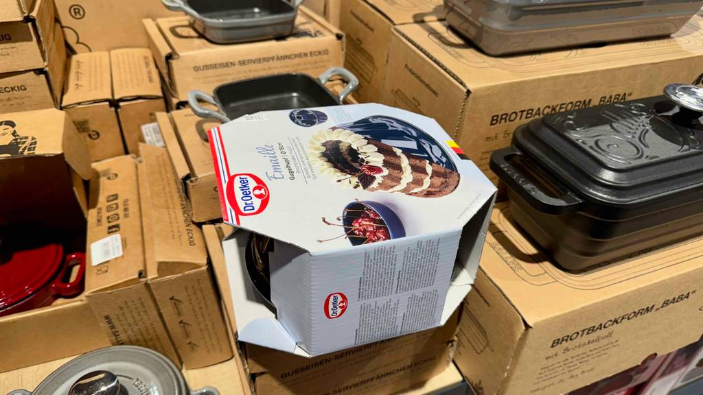 Neben anderen Backformen liegt die schwarze Backform aus Emaille im Test in ihrer Verpackung von Dr. Oetker.