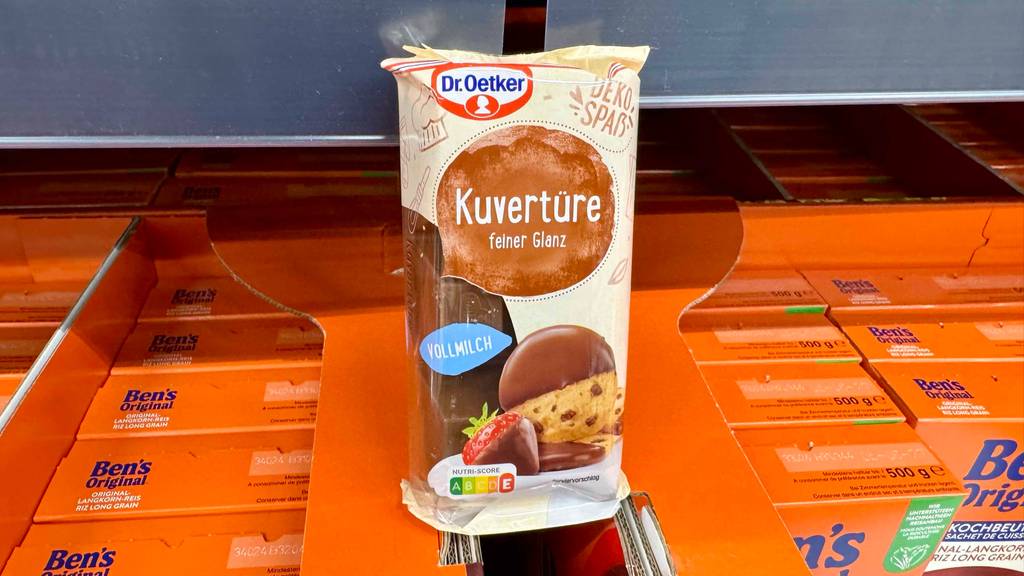 Im Test: Kuvertüre von Dr. Oetker, mit Vollmilchgeschmack, steht innerhalb der Verpackung auf Packungen mit Fertigreis.