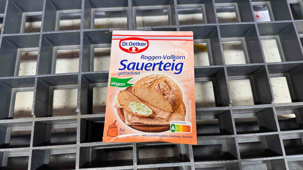 Eine Packung Sauerteig liegt zum Testen auf einem Metallgitter.