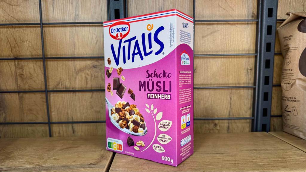 Getestet: Vitalis-Müsli in der 600-g-Packung inklusive Produktangaben steht auf einem Holzregal.